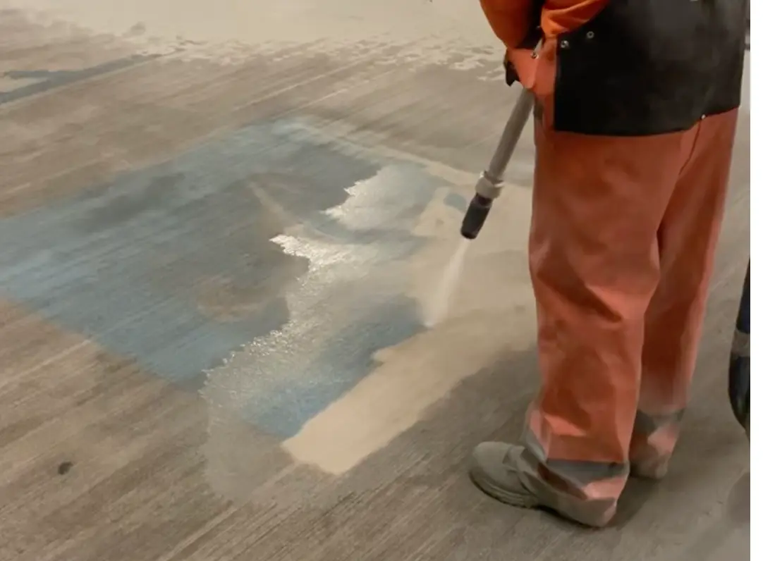 Parking line removal New Orleans — sandblasting blue paint off parking garage floor